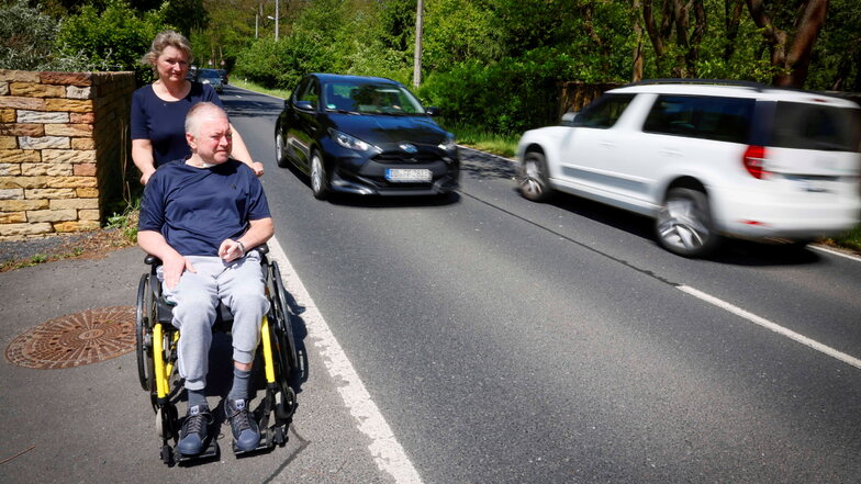 Christine und Siegfried Bach wohnen im Moritzburger Ortsteil Auer, wo zu Stoßzeiten mehr als 500 Autos pro Stunde durchfahren. Durch den fehlenden Fußweg ist der Weg mit dem Rollstuhl durchs Dorf gefährlich.