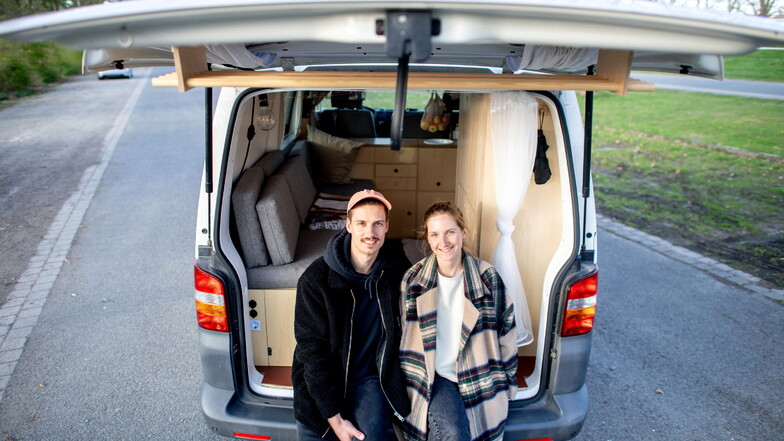 Arne Meyer und Ines Spicker sitzen in ihrem Volkswagen T5, den das Paar in Eigenarbeit zu einem Campervan umgebaut hat.
