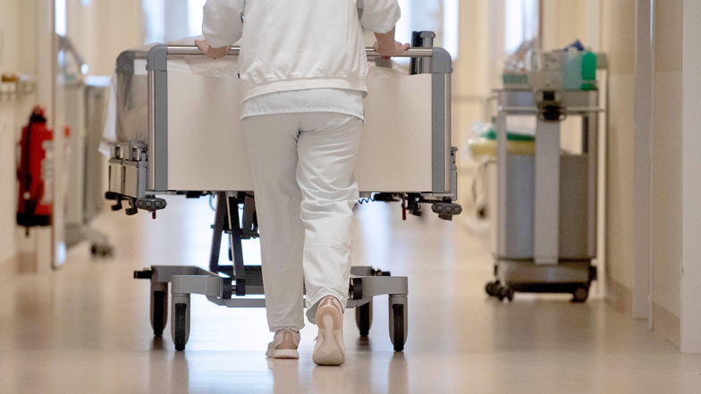 Eine Krankenpflegerin schiebt ein Pflegebett durch einen Flur: Mit der Krankenhausreform im Kreis Görlitz geht es derweil kaum voran.