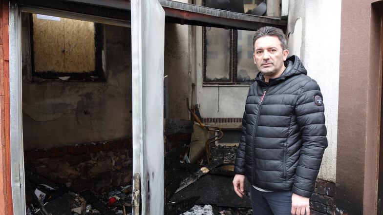 Ferhat Koca, Inhaber der Shisha-Bar, steht nach dem Anschlag an dem Verschlag, der hinter dem Haus an der Bahnhofstraße angezündet wurde. Die Flammen hatten die Fenster zur Bar zerstört.