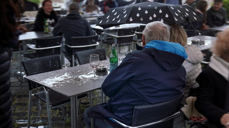 Auch ein Regenschauer kann die Gäste am Neumarkt nicht von ihren Plätzen vertreiben. Dann wird eben einfach der Regenschirm aufgespannt.