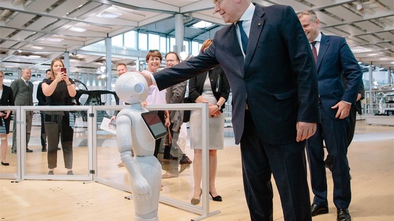 Fürst Albert II. von Monaco streichelt in der Gläsernen VW-Manufaktur den Roboter „Pepper“
