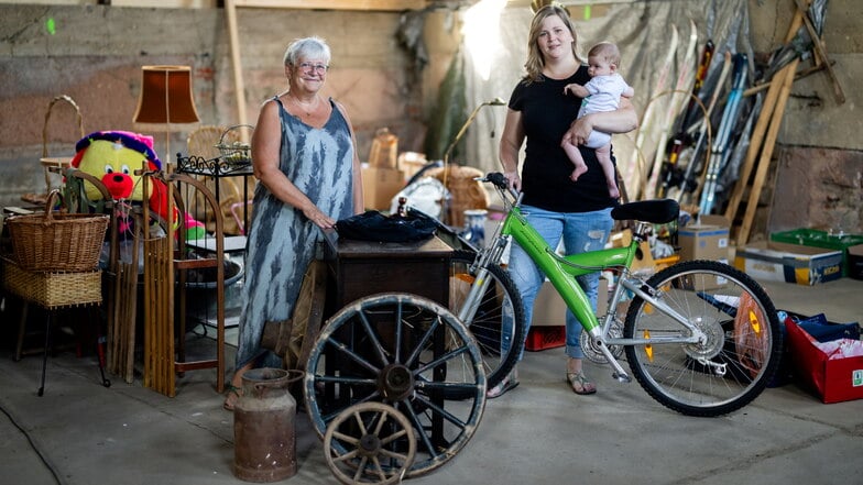 Sabine Thomas (l.) und Linda Jünger vom Heimatverein Steinigtwolmsdorf mit den Spenden von Einwohnern, die am 8. September auf einem Trödelmarkt in Weifa zugunsten der 775-Jahr-Feier 2025 angeboten werden.