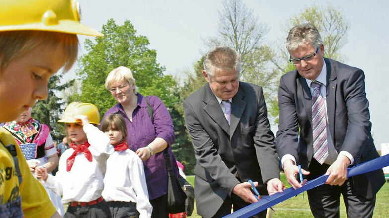 Bürgermeister Reinhard Bork (Mi.) und Landrat Bernd Lange am 29. April 2011 beim symbolischen Bandzerschnitt für den Kindergarten Pfiffikus in Schleife.