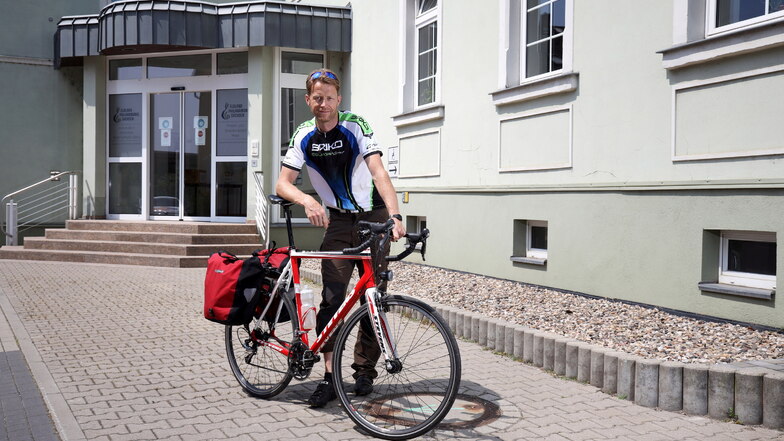 Andreas Dude mit seinem Rennrad vor dem Gebäude der Elbland Philharmonie Sachsen in Riesa. Mehrmals pro Woche radelt der Musiker aus Dresden hierher - unabhängig vom Wetter.