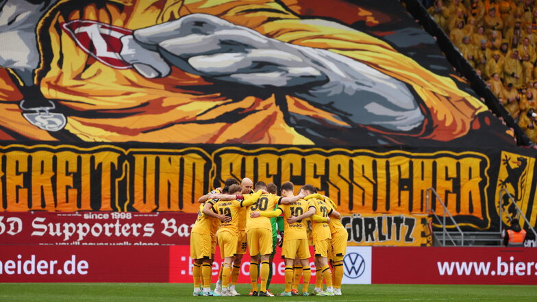 "Kampfbereit und siegessicher" wollen sich die Dresdner Fans heute zeigen. Vor Anpfiff der Partie steht die Mannschaft im Kreis zusammen.