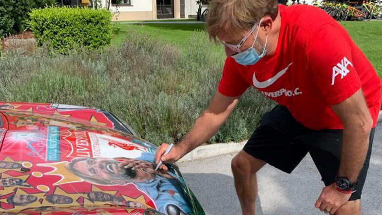 Der Beweis: Jürgen Klopp, coronagerecht mit Mund-Nasen-Schutz, unterzeichnet auf dem Wagen. 