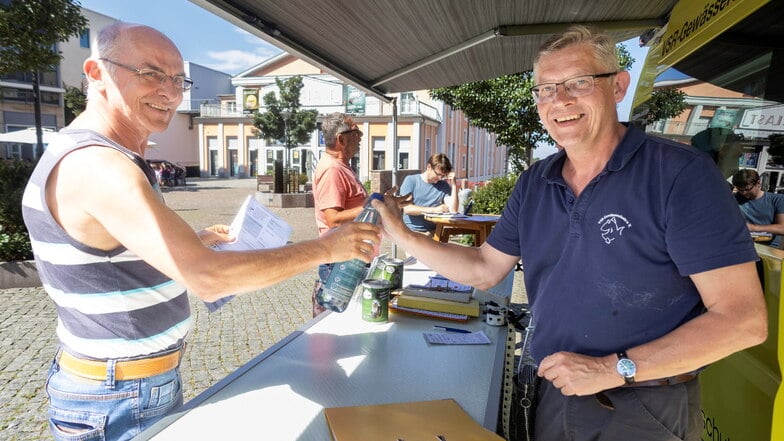 Mario Langer übergibt seine Wasserprobe an Matthias Ahlbrecht vom VSR Gewässerschutz