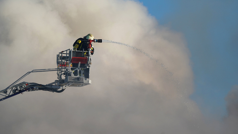 Feuerwehreinsatzkräfte löschen einen Großbrand in einem Gewerbepark in Zwenkau.
