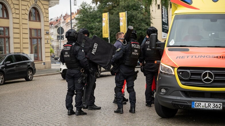 Schwer bewaffnete Polizisten stehen Donnerstagmittag vor einem Rettungswagen bei einem Polizeieinsatz auf dem Obermarkt in Görlitz.