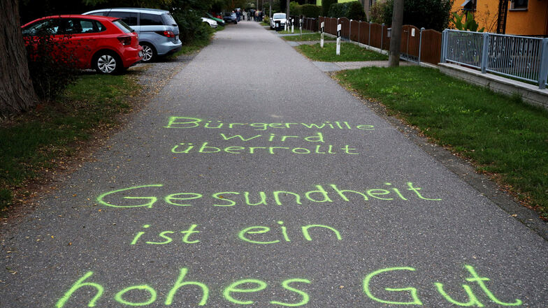 Mit Sprüchen auf der Fahrbahn der Sackgasse protestieren Zeithainer gegen das Bauprojekt in ihrer unmittelbaren Nachbarschaft an der Langenberger Straße.