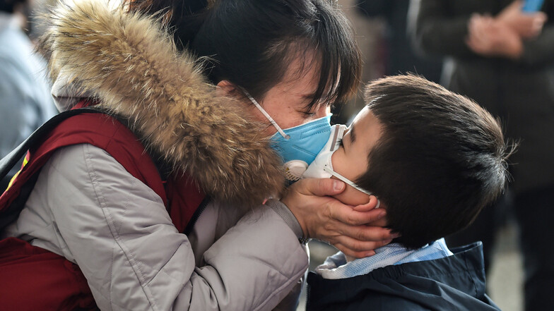 Eine Mitarbeiterin eines Ärzteteams küsst ihren Sohn, bevor sie vom Flughafen Yaoqiang aus in die Provinz Hubei aufbricht. Die 12. Gruppe von 170 medizinischen Mitarbeitern aus Shandong fliegt nach  Hubei, um dort bei der Kontrolle des Coronavirus zu helf