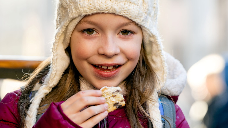 Die Achtjährige Nadine Winter aus Bautzen hat das erste Stück Stollen vom Oberbürgermeister ergattert.  Nun freut sie sich auf Karussell, Eisbahn und Langos.