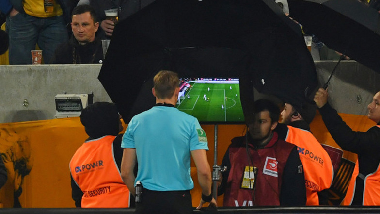 Schiedsrichter Martin Petersen überprüft am Monitor neben dem Spielfeld die Szene und entscheidet dann: kein Tor.