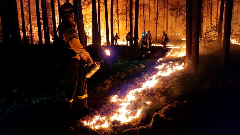 Einsatzkräfte legen ein Gegenfeuer, um eine weitere Ausbreitung des Waldbrandes zu verhindern und die Feuerwehr bei der Bekämpfung des Feuers zu unterstützen.