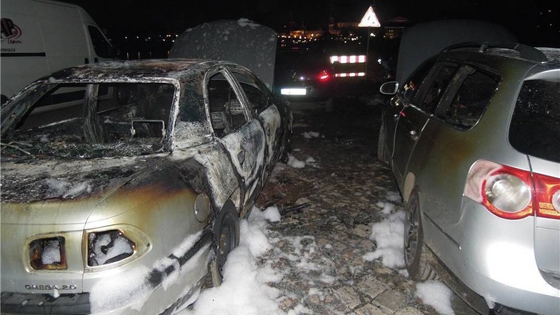 Nur noch Schrott: der ausgebrannte Opel. Schwer angesengt steht rechts daneben der betroffene VW.