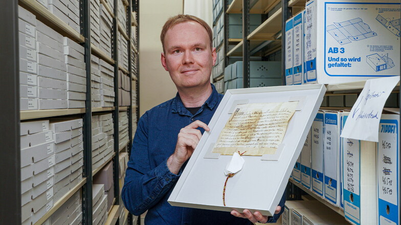 Bautzens neuer Stadtarchivar Rico Heyl zeigt eine der Papst-Urkunden. Der komplette Bestand ist mittlerweile digitalisiert. Andere historische Dokumente warten noch darauf, erschlossen zu werden.