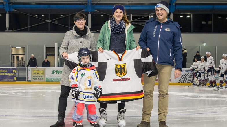 Ein bewegender Moment: Hanna Günzel und ihr Papa Uwe bekommen das Trikot von Eishockey-Torfrau Ivonne Schröder (Mitte) und Vereinsbotschafterin Susan Lill auf dem Nieskyer Eis überreicht.