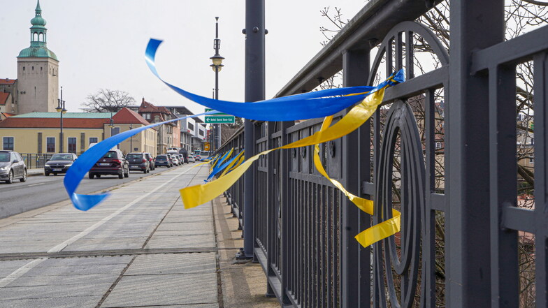 Mit blau-gelben Bändchen an der Friedensbrücke gegen Krieg in der Ukraine