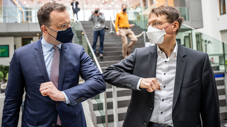 Jens Spahn (CDU, l), Bundesminister für Gesundheit, verabschiedet sich mit einem Ellenbogen-Kick von Karl Lauterbach, SPD-Gesundheitsexperte.