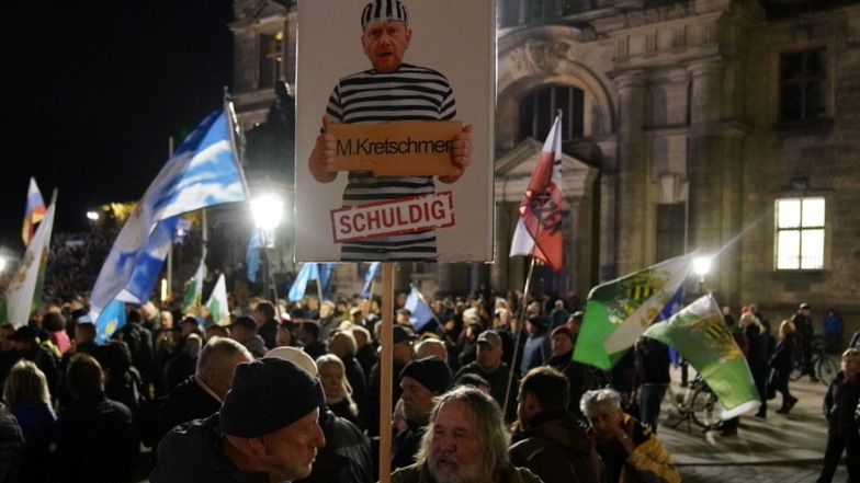 Ein verunglimpfendes Plakat gegen Sachsens Ministerpräsidenten Michael Kretschmer bei der Pegida-Demonstration am Montagabend in Dresdens Innenstadt.