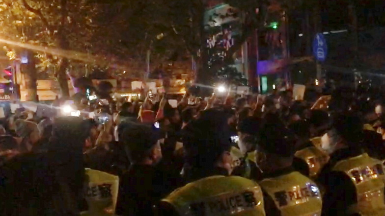 Shanghai: In diesem Bild aus einem Video beobachtet die Polizei (im Vordergrund) die Demonstranten in Shanghai.
