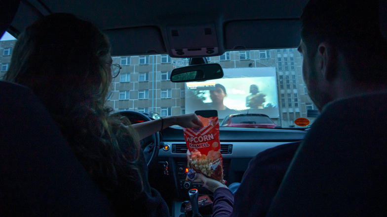 Popcorn hinterm Lenkrad: Im Autokino auf dem Bautzener Flugplatz gab es am Freitag den Film "Parasite" zu sehen. Etwa 40 Autos hatten dafür vor der Leinwand eingeparkt.
