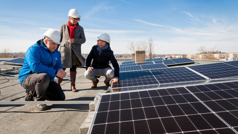 Repräsentanten der Meißner Stadtwerke und SEEG inspizieren die Solar-Module auf dem Dach des Wohnhauses.