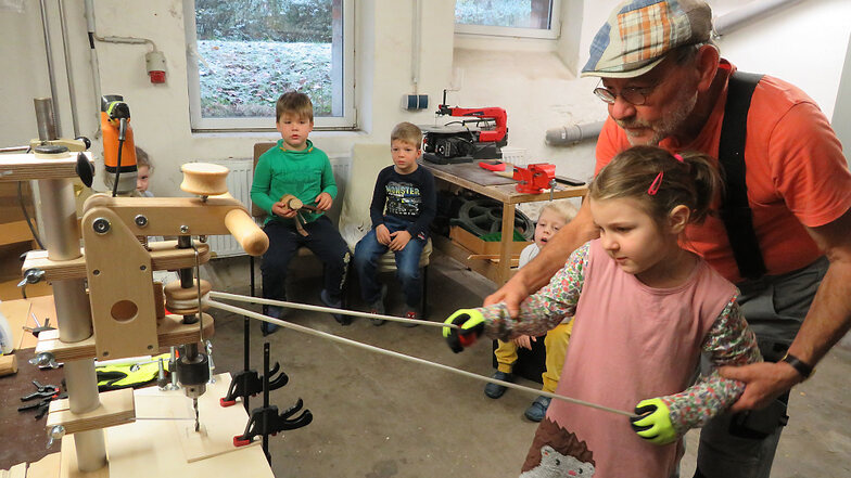 Handwerk kann Spaß machen! Thomas Stolle hilft, die neu angeschaffte Bohrmaschine mit einem Seil anzutreiben.