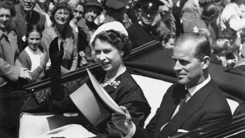 1952: Königin Elizabeth II. fährt in einer offenen Kutsche mit Prinz Philip am zweiten Tag des königlichen Treffens in Ascot. Foto: Eddie Worth/AP/dpa (Archivbild)