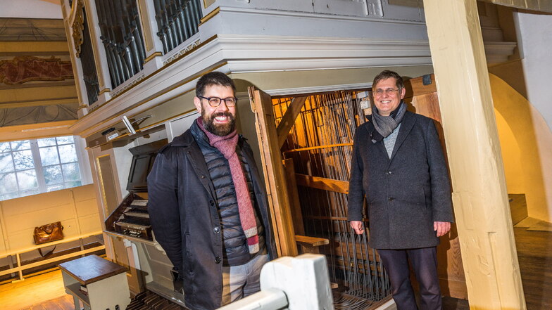 Sie freuen sich darauf, dass die Gröbaer Orgel bald saniert wird: Pfarrer Jan Quenstedt (l.) und Sebastian Schwarze-Wunderlich von der Evangelisch-Lutherischen Kirchgemeinde Riesa vor dem Instrument.