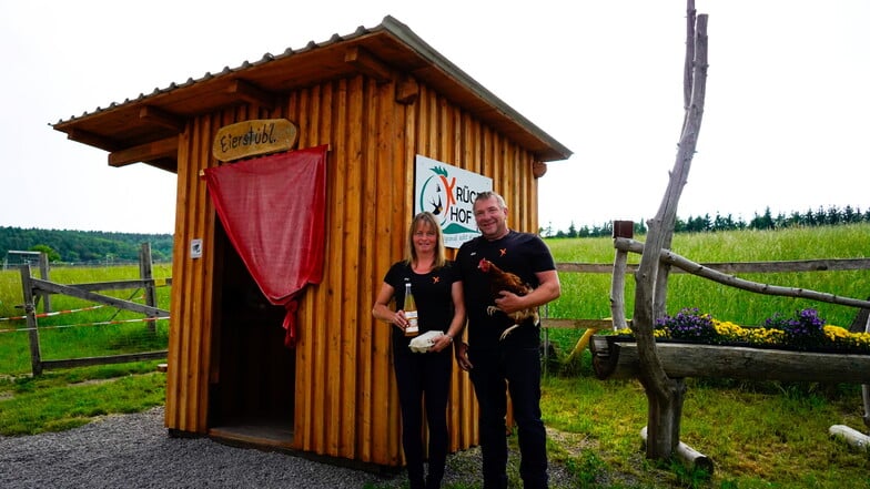Steffi und Andreas Krüger an ihrem Eierautomaten. Die Hühner leben auf der Wiese hinter dem Holzhäuschen.