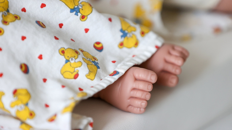 Die Füße der Übungspuppe eines Neugeborenen gucken unter einer Decke in der Lernklinik der Medizinischen Fakultät heraus.