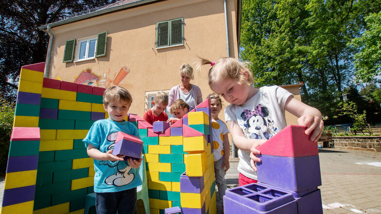 Im „Haus der kleinen Stifte Berta Semmig“ in Döbeln spielen die Kinder im Außengelände in vier getrennten Bereichen. In einem bauen sie sich ein kleines buntes Häuschen.