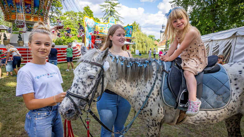 Hannah (li.) und Annalena passen auf, dass dreijährige Mia sicher auf dem Pony sitzt.