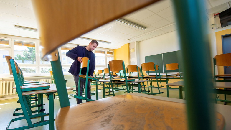 Ein Start im doppelten Sinne: Der neu ernannte Schulleiter der 2. Oberschule Am Schacht Großenhain, Marcus Weinhold, stellt in einem Klassenzimmer schon mal die Stühle für seine Schüler bereit.