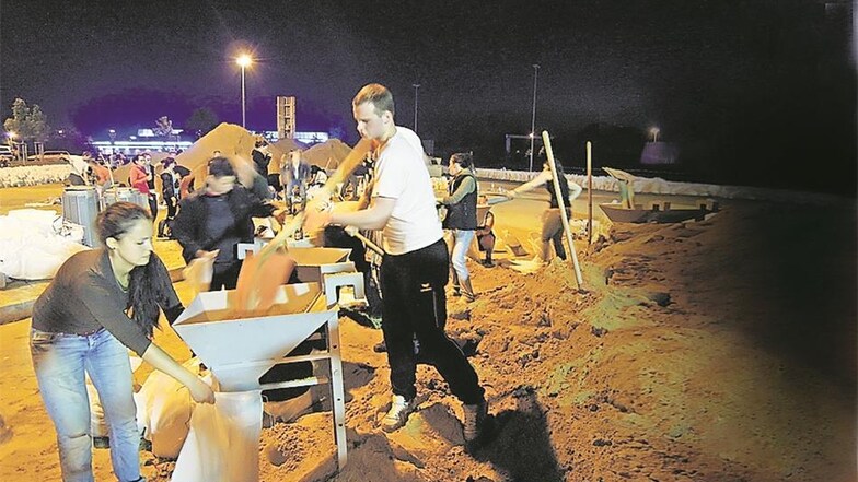Hunderte Helfer befüllen über Nacht die Sandsäcke auf dem Autobahnrastplatz. Sie kamen spontan und freiwillig. Bis gestern hatten sie eine Viertelmillion gefüllt. Foto: Alexander Schneider