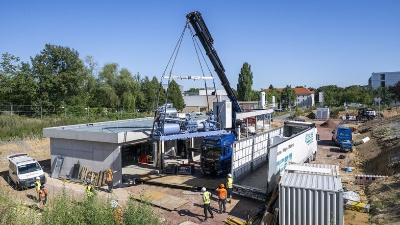 Auf einem Schwertransport sind die Wärmepumpen am TU-Hochleistungsrechenzentrum an der Südhöhe in Dresden angerollt. Ein Kran hebt die jeweils neun Tonnen schweren Anlagen zum neuen Technikbauwerk, wo sie installiert werden.