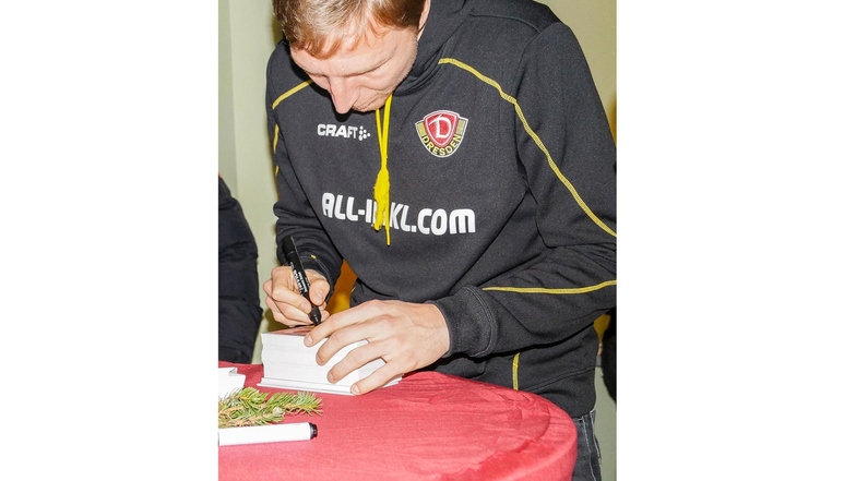 Dynamo-Mannschaftskapitän Marco Hartmann beim Signieren von Autogrammen.