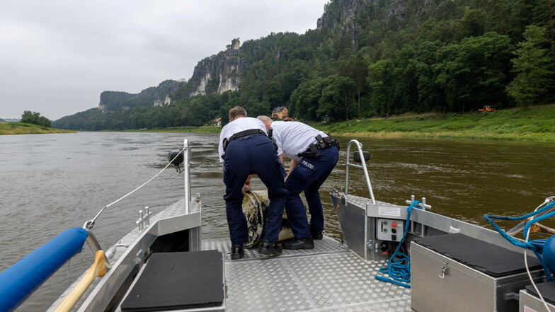 Hindernis auf der Bundeswasserstraße: Die Polizisten Breitfeld und Lisofsky hieven eine herrenlose Plastetonne über die abgesenkte Bugklappe auf ihr Boot.