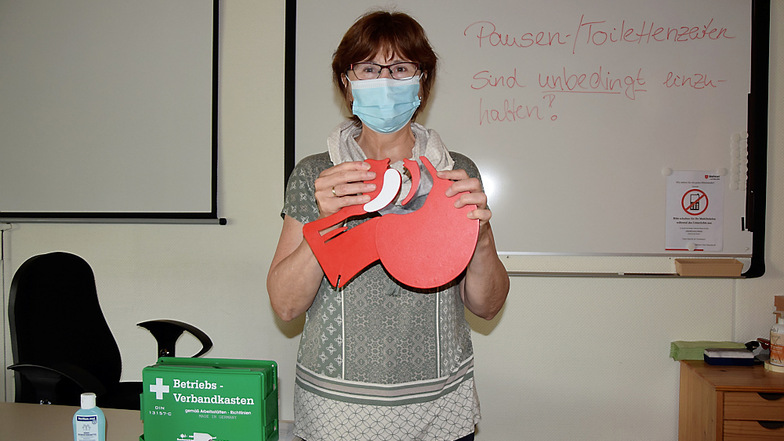Erste-Hilfe-Ausbilderin Irina Mücke im Unterrichtsraum mit einem Modell der oberen Atemwege des menschlichen Körpers.