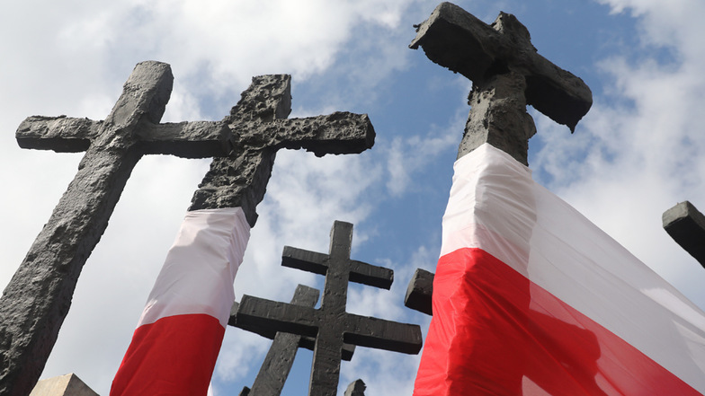 Polnische Flaggen sind an einem Denkmal für die im II. Weltkrieg Gefallenen und Ermordeten angebracht.