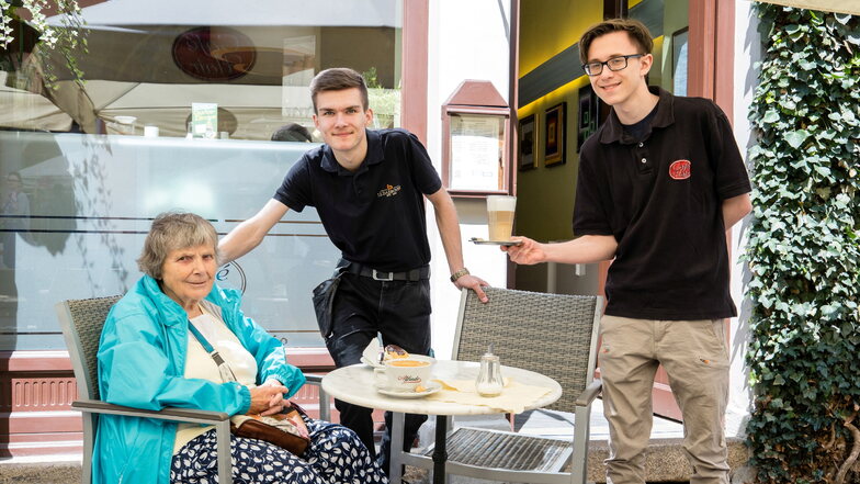 Auszubildender Eric Schäfer (Mitte) und Praktikant Michal Adam Szczesniak servieren Stammgästin Sonja Dité im Café Flair einen Kaffee.  Laut Lesermeinung der zweitbeste, den die Region zu bieten hat.