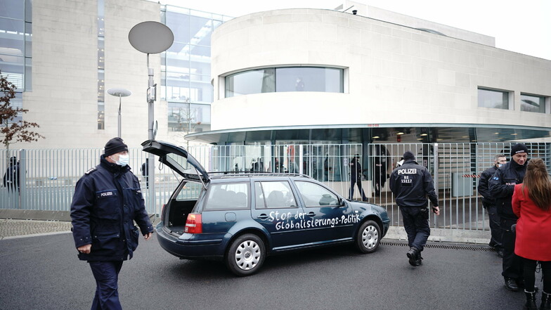 Ein Auto steht am Mittwoch vor dem Tor des Bundeskanzleramts. Auf der Tür ist die Aufschrift "Stop der Globalisierungs-Politik" zu lesen.