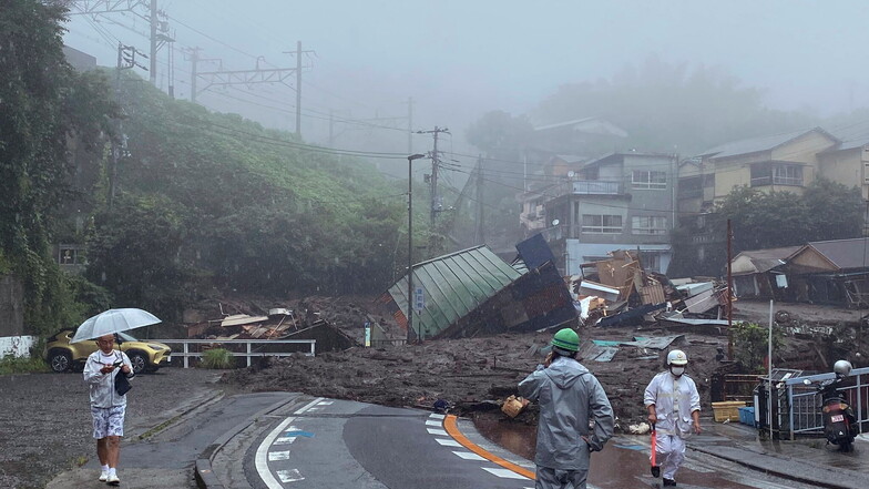 Japan, Atami: Eine Straße ist nach starkem Regen mit Schlamm, Geröll und Trümmern bedeckt.