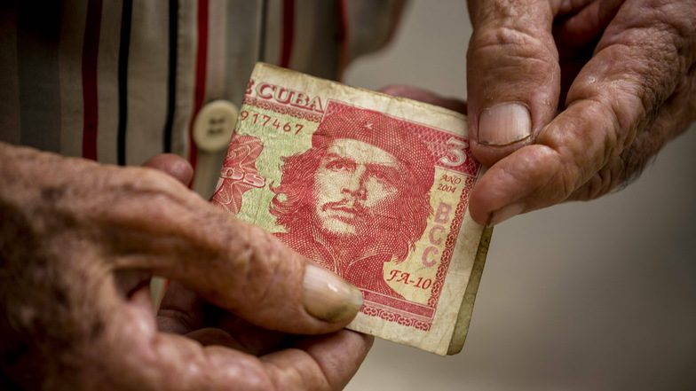 Kubaner mit einem drei Peso Geldschein mit dem Portrait von Ernesto Che Guevara.