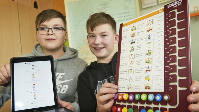 Eric (links) zeigt ein Tablet, Vincent ein Logico. Beide Hilfsmittel werden an der Pestalozzi-Oberschule Hartha im Englischunterricht eingesetzt.
