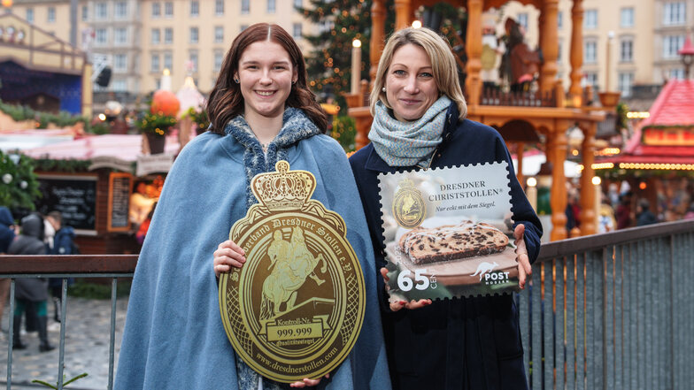 Stollenmädchen Nelly Köhler (links) und Nicole Keßler von Post Modern haben am Donnerstag die neue Stollenbriefmarke auf dem Dresdner Striezelmarkt vorgestellt.