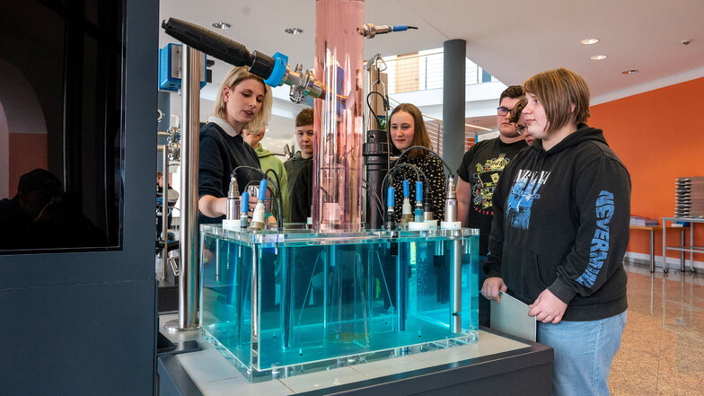 Glasapparatebau-Meisterin Sophie Herforth erklärt den Jugendlichen bei Endress+Hauser am Modell die Herstellung von Sensoren zur Flüssigkeitsanalyse.