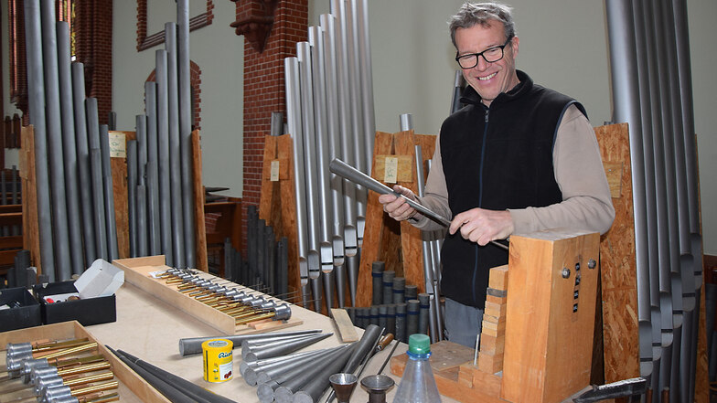 Steffen Hartmann gehört zu den Experten von der Dresdener Firma Jehmlich, die derzeit die Orgel in der katholischen Pfarrkirche „Heilige Familie“ in Schuss bringt. Im Bild zu sehen ist er bei der Bearbeitung der metallenen Orgelpfeifen.